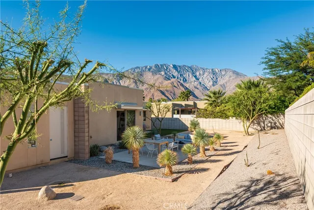 a view of backyard with a table and chairs under an umbrella