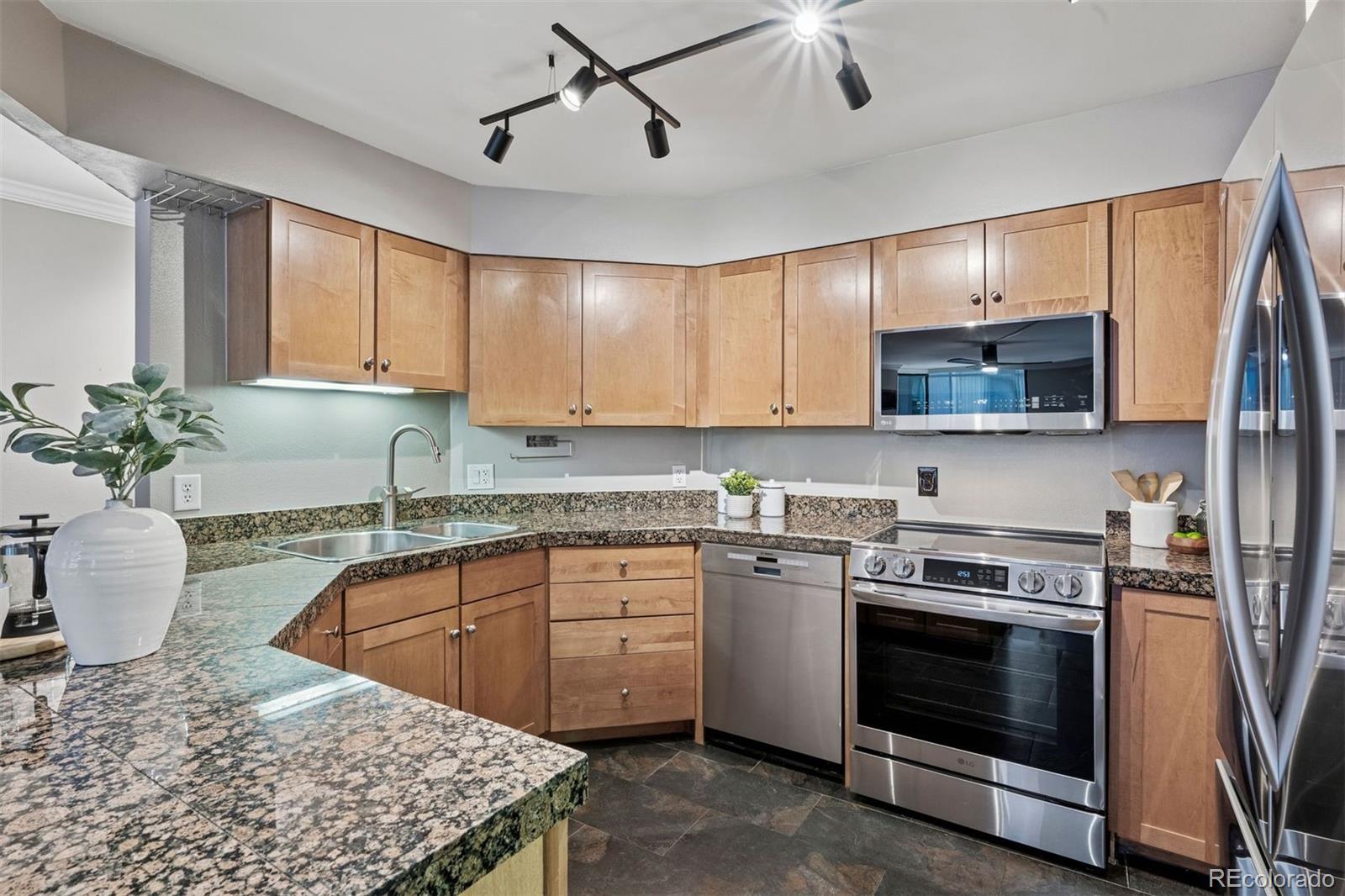 1625 Larimer Street, Unit 1208 Denver, CO 80202 - Photo 16 of 41 a kitchen with stainless steel appliances granite countertop a stove a sink and a microwave