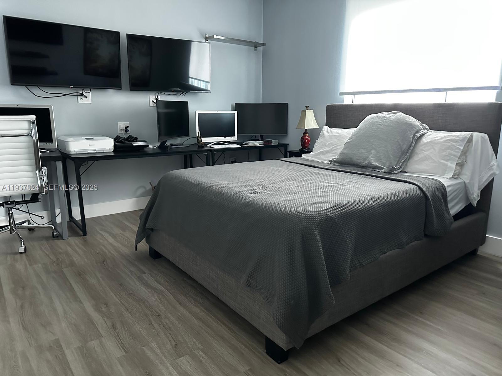 500 Brickell Avenue, Unit 3307 Miami, FL 33131 - Photo 13 of 30 a bedroom with a bed a television and wooden floor