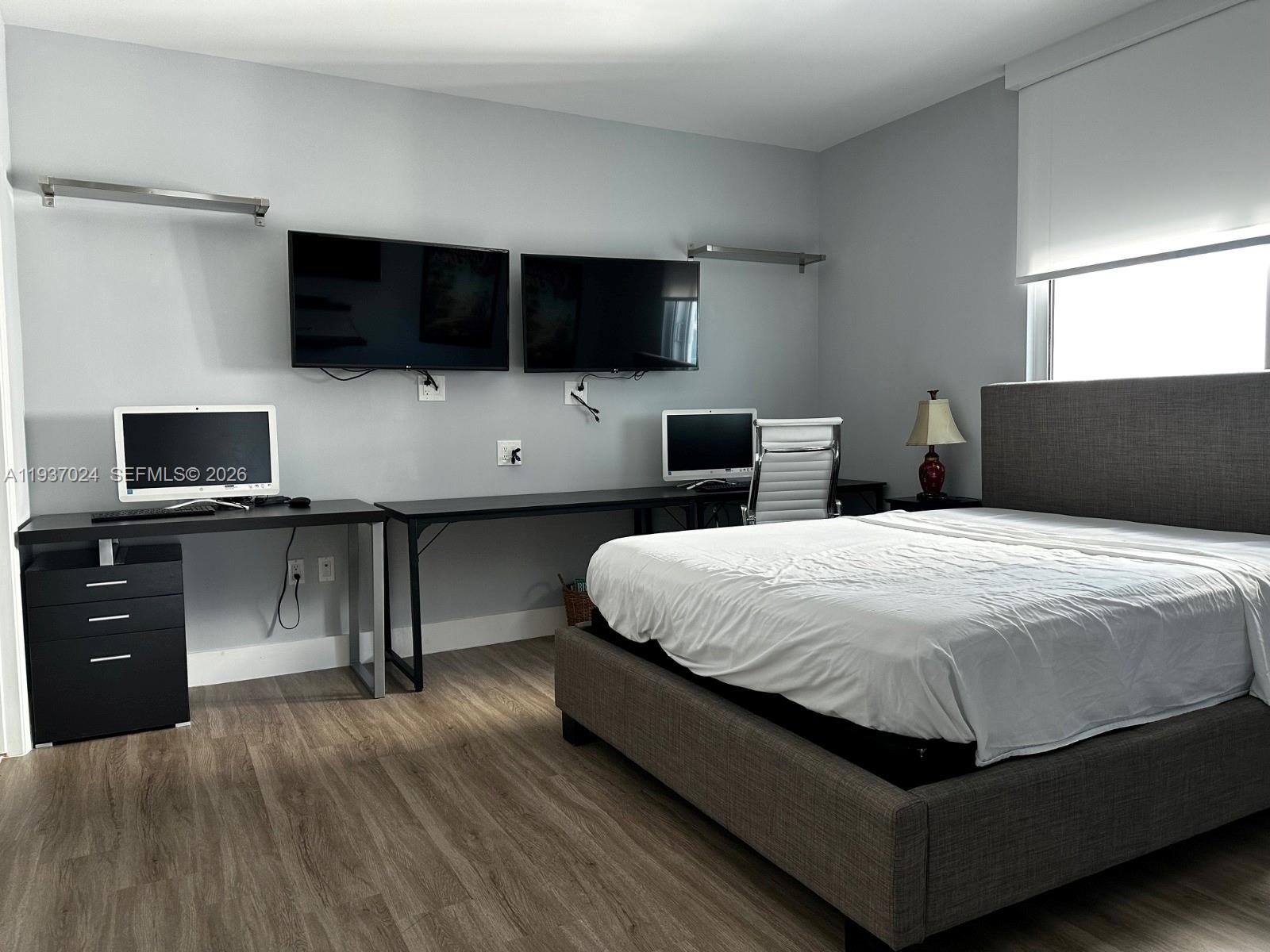 500 Brickell Avenue, Unit 3307 Miami, FL 33131 - Photo 6 of 30 a spacious bedroom with a bed and a flat screen tv