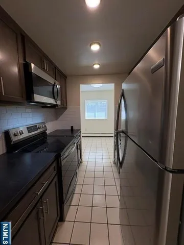 a kitchen with stainless steel appliances granite countertop a stove a refrigerator and a microwave