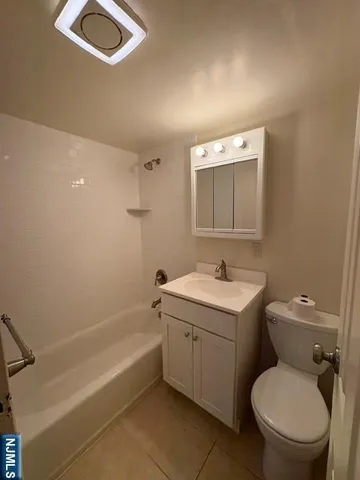 a bathroom with a granite countertop toilet a sink and mirror