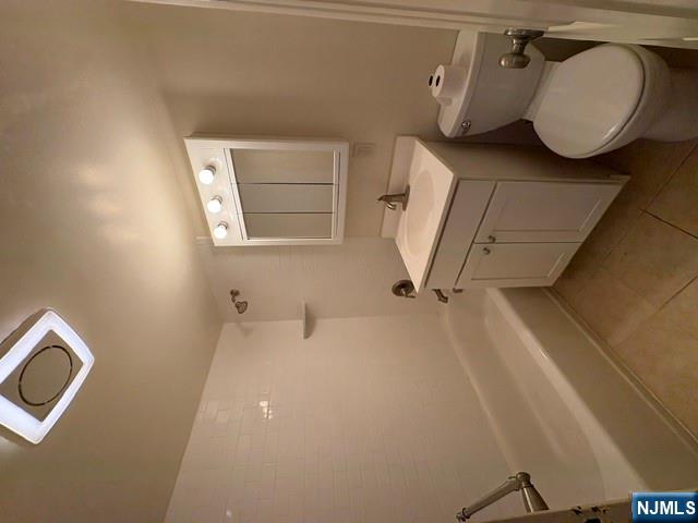 1 Simone Place, Unit 2F Bergenfield, NJ 07621 - Photo 12 of 13 a bathroom with a granite countertop toilet a sink and mirror