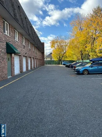 a view of a street with a cars parked in front of house