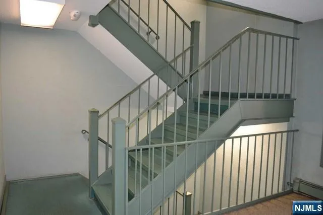 a view of staircase with railing and white walls