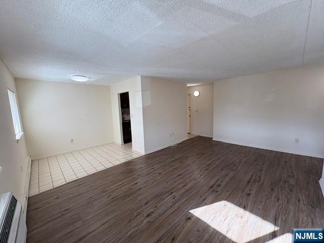 1 Simone Place, Unit 2F Bergenfield, NJ 07621 - Photo 8 of 13 a view of an empty room with wooden floor and a painting on the wall