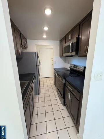 a kitchen with stainless steel appliances a refrigerator and a stove top oven
