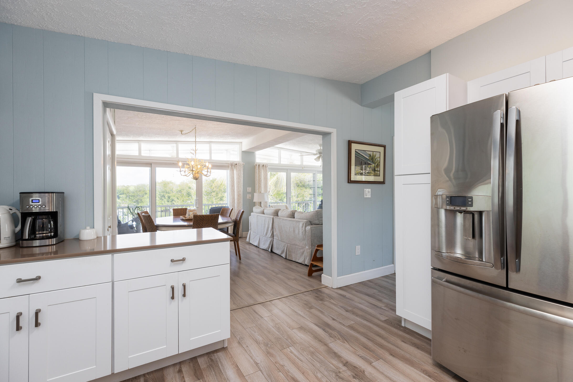 39 Lake Shore Drive Key Largo, FL 33037 - Photo 8 of 47 a kitchen with white cabinets and wooden floor