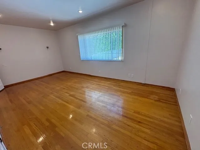 an empty room with wooden floor and a window