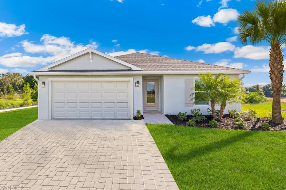 437 Rathburn Street Lehigh Acres, FL 33974 - Photo 1 of 23 Model Home. Single-story residence featuring a paver driveway, an attached two-car garage, and a covered entryway