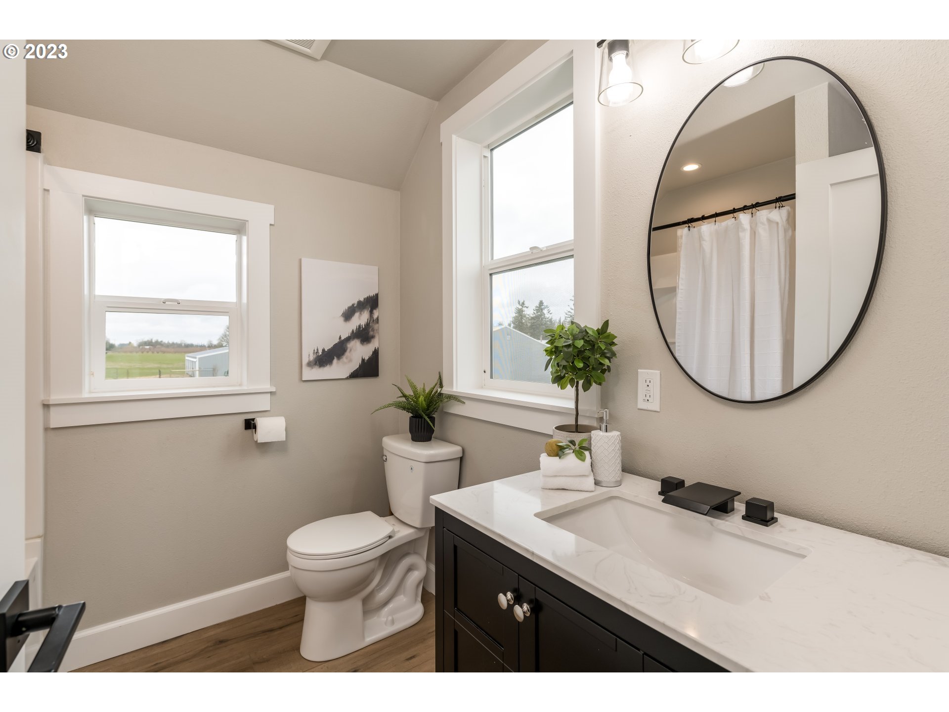 8951 South Schneider Road Canby, OR 97013 - Photo 21 of 39 a bathroom with a toilet a sink a mirror and a window