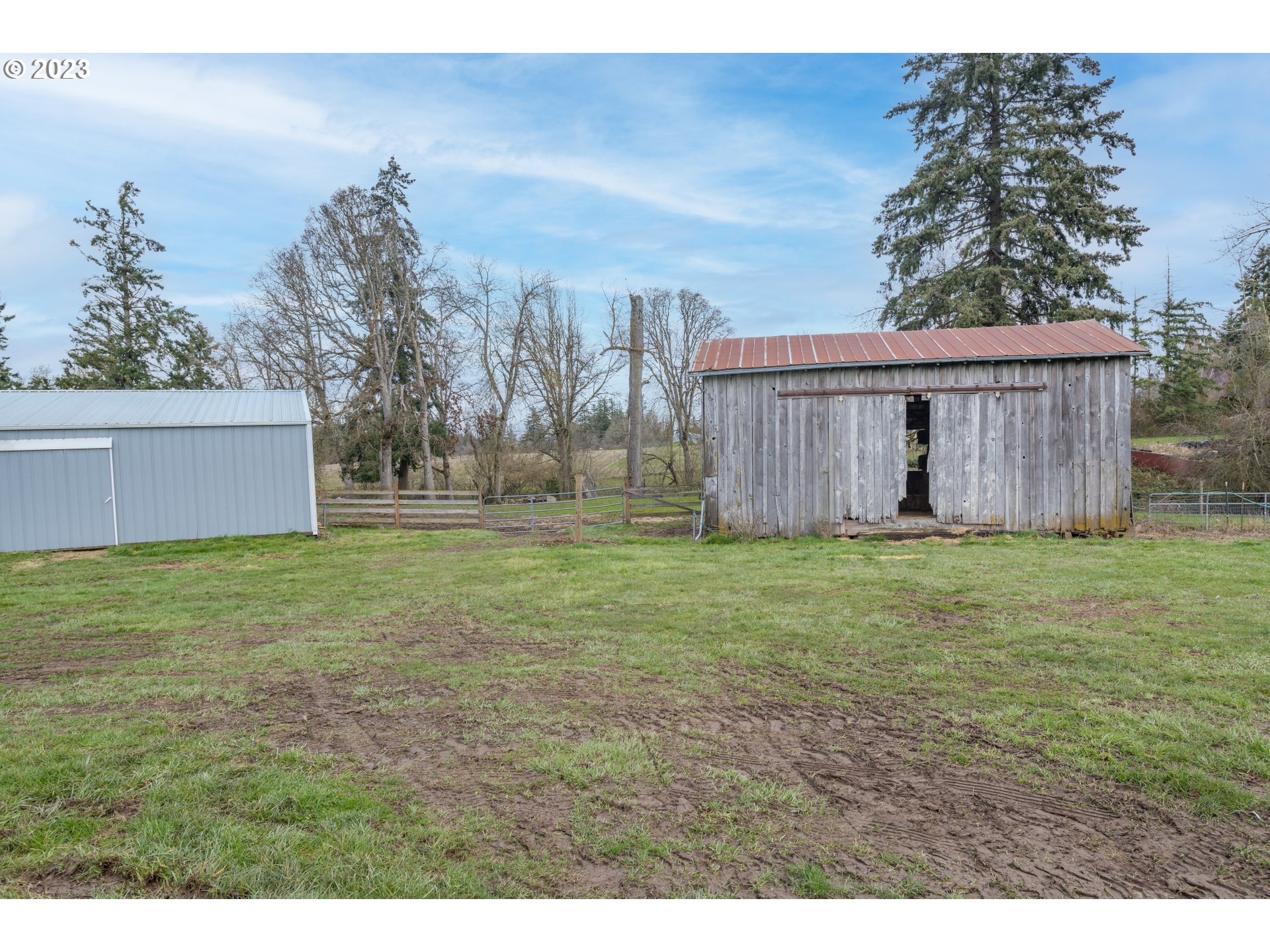 8951 South Schneider Road Canby, OR 97013 - Photo 31 of 39 a view of a backyard with barn and wooden fence