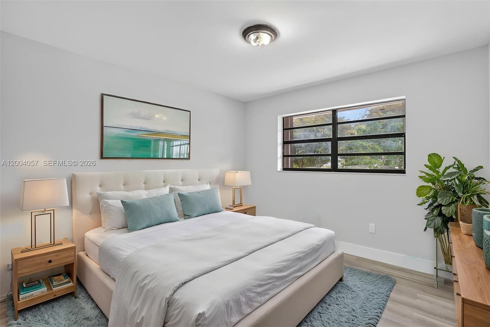 2276 West 56th Street, Unit 109 Hialeah, FL 33016 - Photo 12 of 22 a bedroom with a bed and a painting on the wall