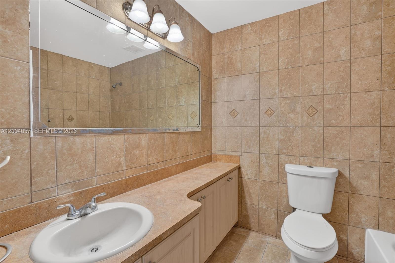 2276 West 56th Street, Unit 109 Hialeah, FL 33016 - Photo 14 of 22 a bathroom with a sink a toilet and a mirror