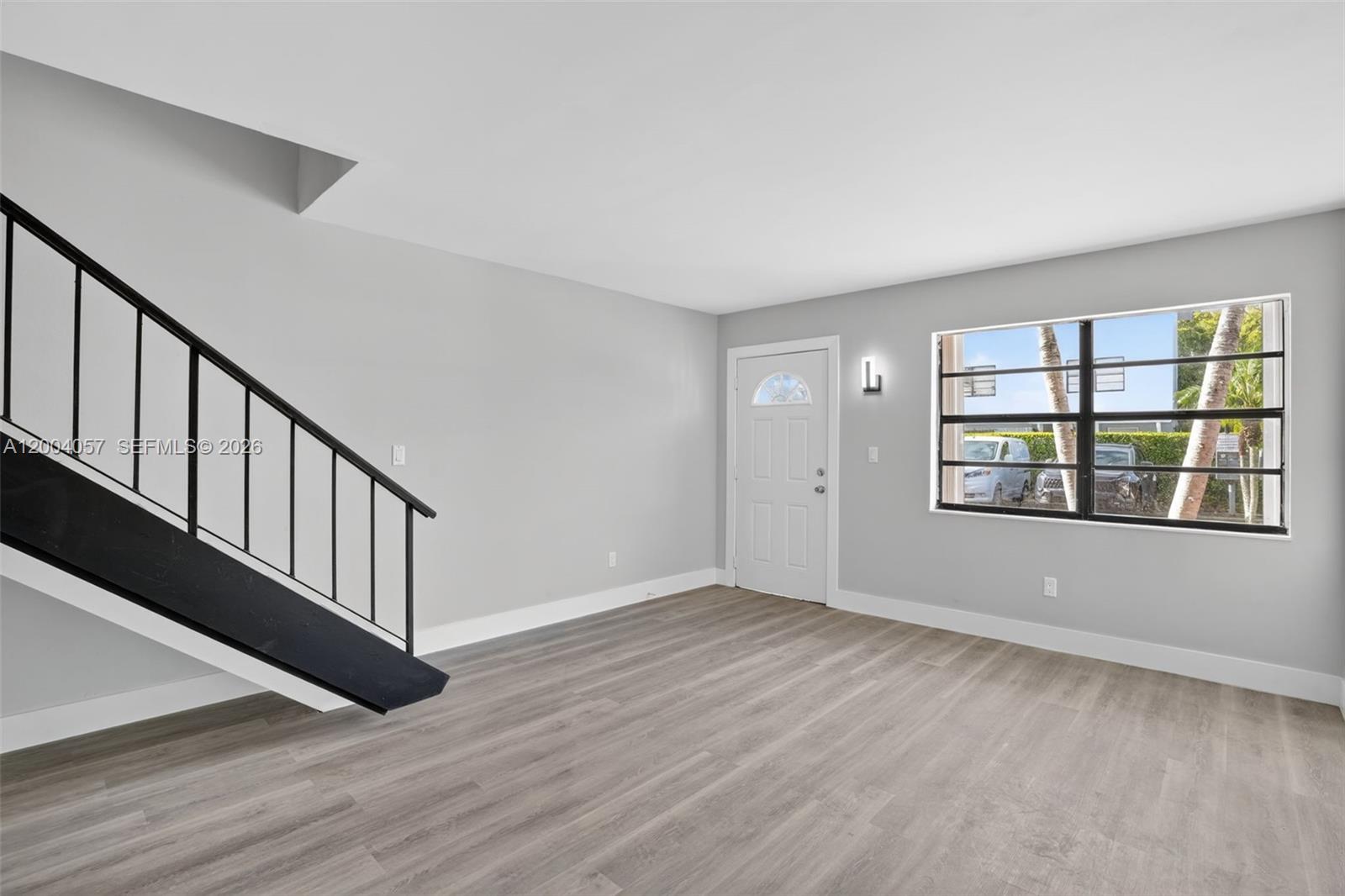 2276 West 56th Street, Unit 109 Hialeah, FL 33016 - Photo 3 of 22 a view of an empty room with wooden floor and a window