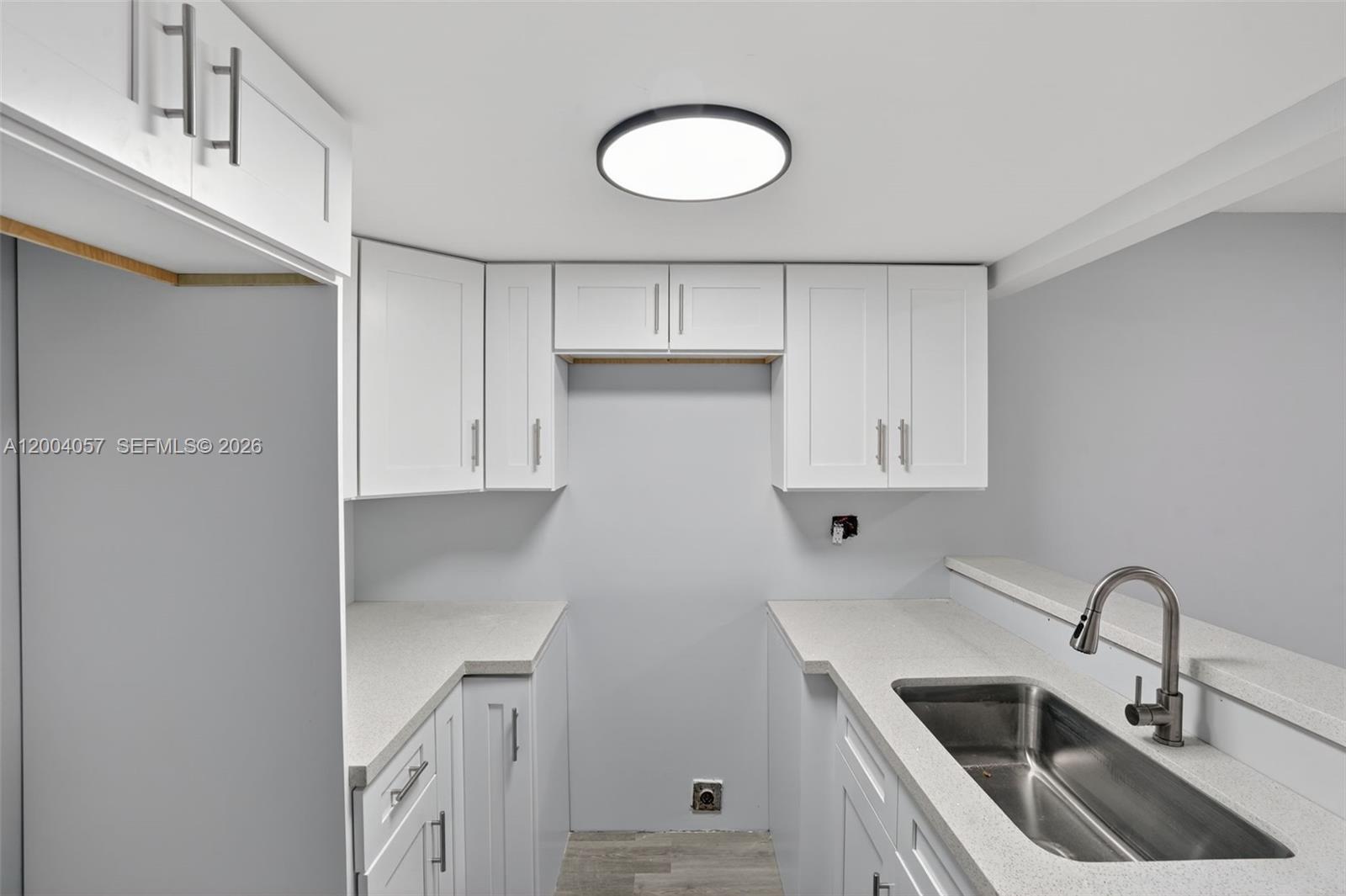 2276 West 56th Street, Unit 109 Hialeah, FL 33016 - Photo 5 of 22 a kitchen with a sink cabinets and stainless steel appliances