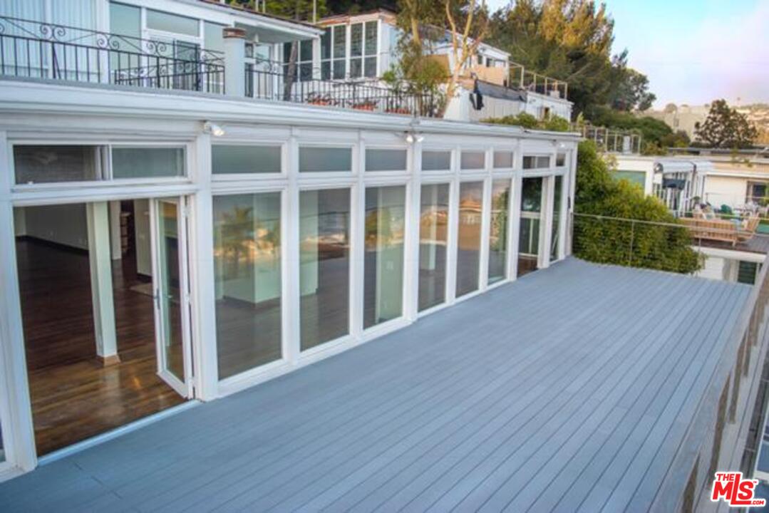18125 Coastline Drive, Unit A Malibu, CA 90265 - Photo 3 of 9 a view of backyard with large windows and wooden floor