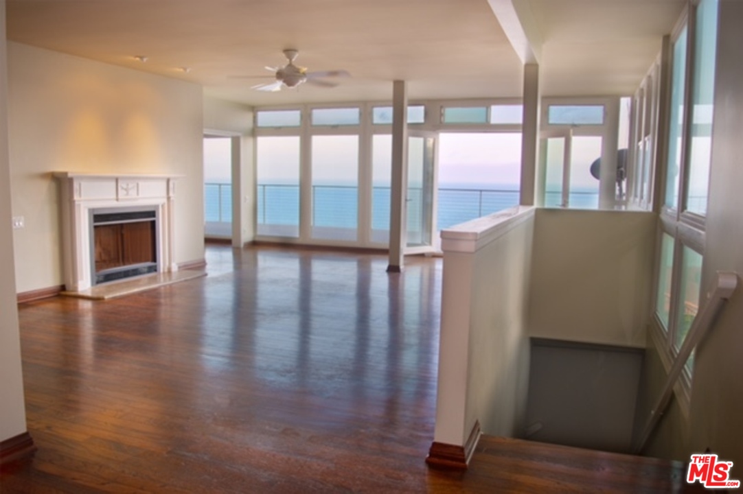 18125 Coastline Drive, Unit A Malibu, CA 90265 - Photo 4 of 9 a view of an empty room with wooden floor and a fireplace