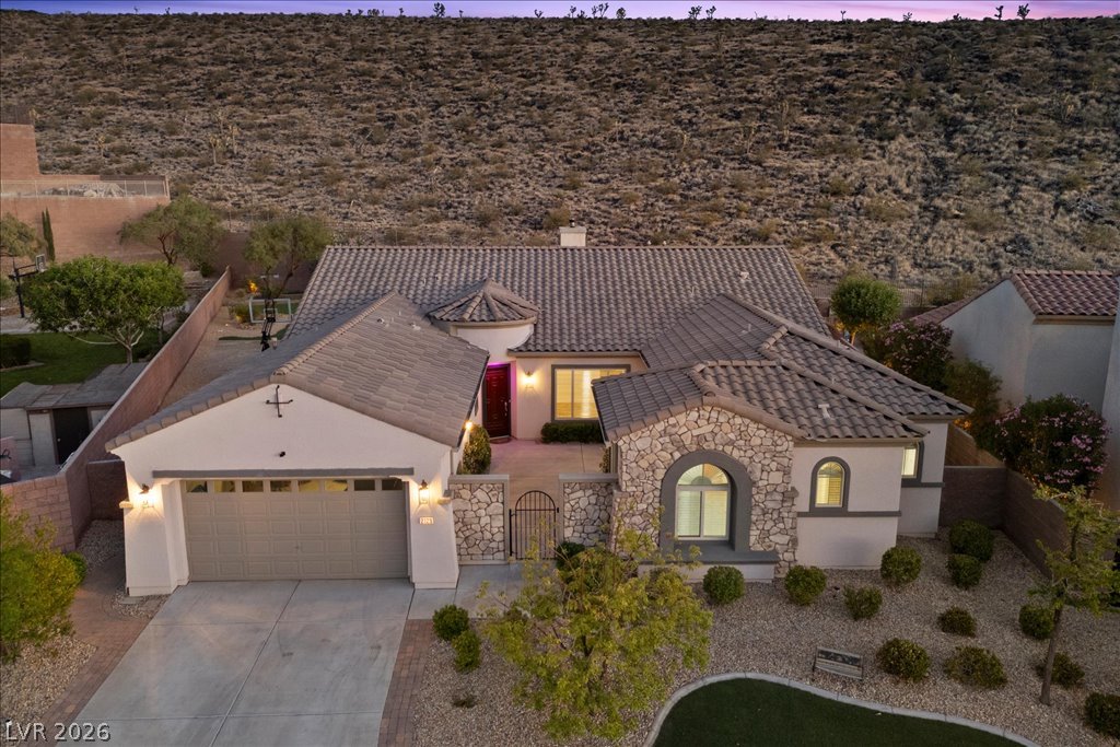 2125 De Rouge Avenue Henderson, NV 89044 - Photo 85 of 96 An inviting entry showcases architectural stone accents and a secure, gated courtyard leading to the main entrance.