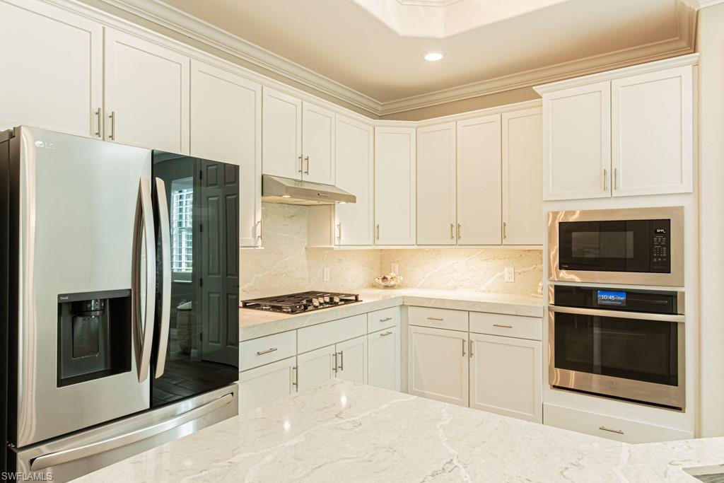1869 Mustique Street Naples, FL 34120 - Photo 11 of 48 a kitchen with stainless steel appliances white cabinets and a refrigerator