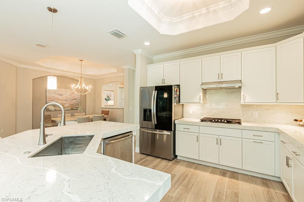 1869 Mustique Street Naples, FL 34120 - Photo 12 of 48 a kitchen with stainless steel appliances granite countertop a sink stove and refrigerator
