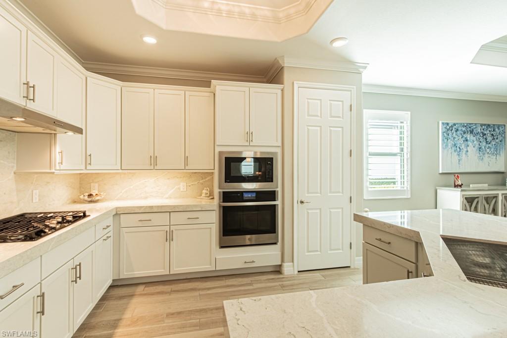 1869 Mustique Street Naples, FL 34120 - Photo 13 of 48 a kitchen with stainless steel appliances granite countertop a stove and a sink