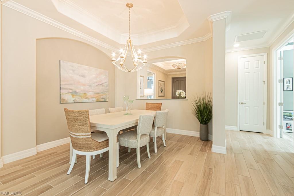 1869 Mustique Street Naples, FL 34120 - Photo 14 of 48 a view of a dining room with furniture wooden floor and chandelier