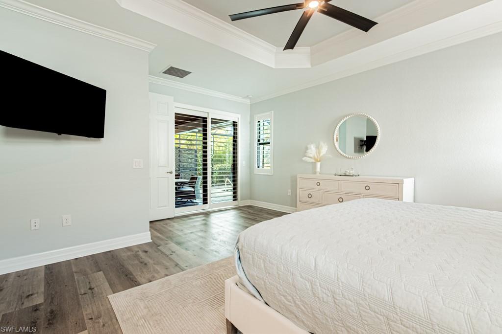 1869 Mustique Street Naples, FL 34120 - Photo 19 of 48 a bedroom with a bed a flat tv screen and a large window