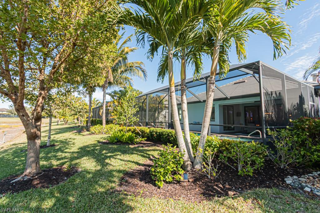 1869 Mustique Street Naples, FL 34120 - Photo 30 of 48 a view of a white house with a big yard and large trees
