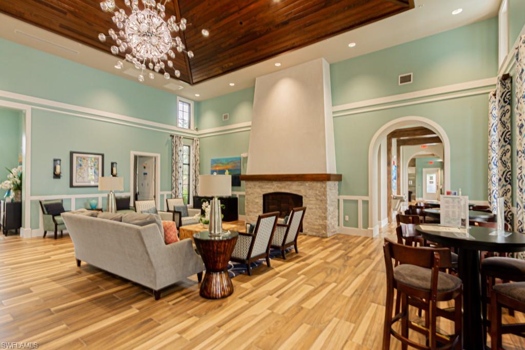 1869 Mustique Street Naples, FL 34120 - Photo 43 of 48 a living room with furniture a fireplace and a chandelier
