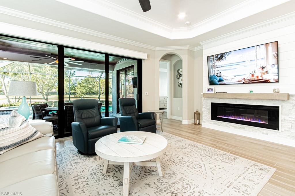 1869 Mustique Street Naples, FL 34120 - Photo 5 of 48 a living room with furniture a fireplace and a floor to ceiling window