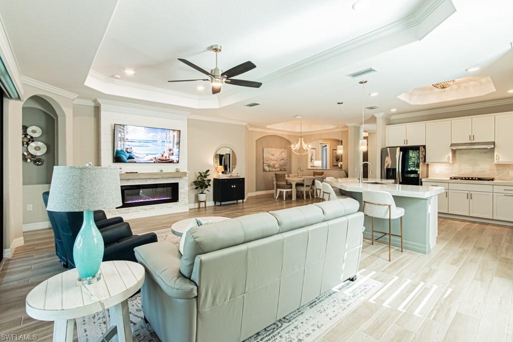 1869 Mustique Street Naples, FL 34120 - Photo 6 of 48 a living room with furniture kitchen view and a fireplace