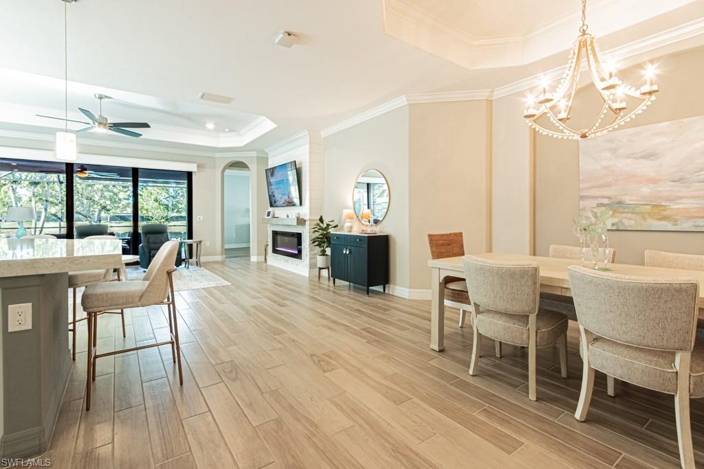 1869 Mustique Street Naples, FL 34120 - Photo 8 of 48 a dining room with furniture a chandelier and wooden floor
