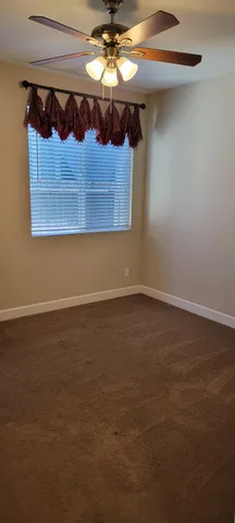 a view of an empty room with a chandelier fan