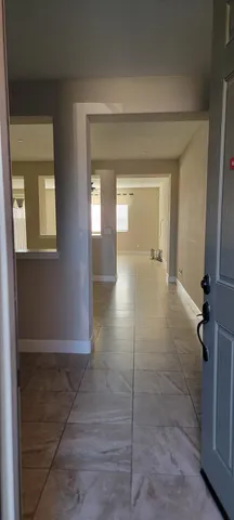 a view of a hallway with chandelier fan and glass door