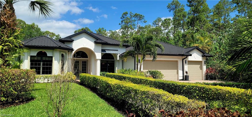 2360 19th Street Southwest Naples, FL 34117 - Photo 1 of 50 View of front of property with a garage, stucco siding, french doors, and a front lawn