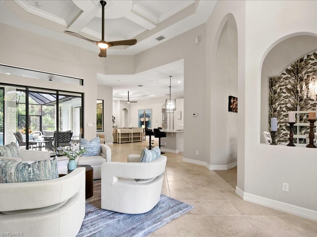 2360 19th Street Southwest Naples, FL 34117 - Photo 12 of 50 Living room featuring a towering ceiling, ceiling fan, coffered ceiling, light tile patterned floors, and baseboards
