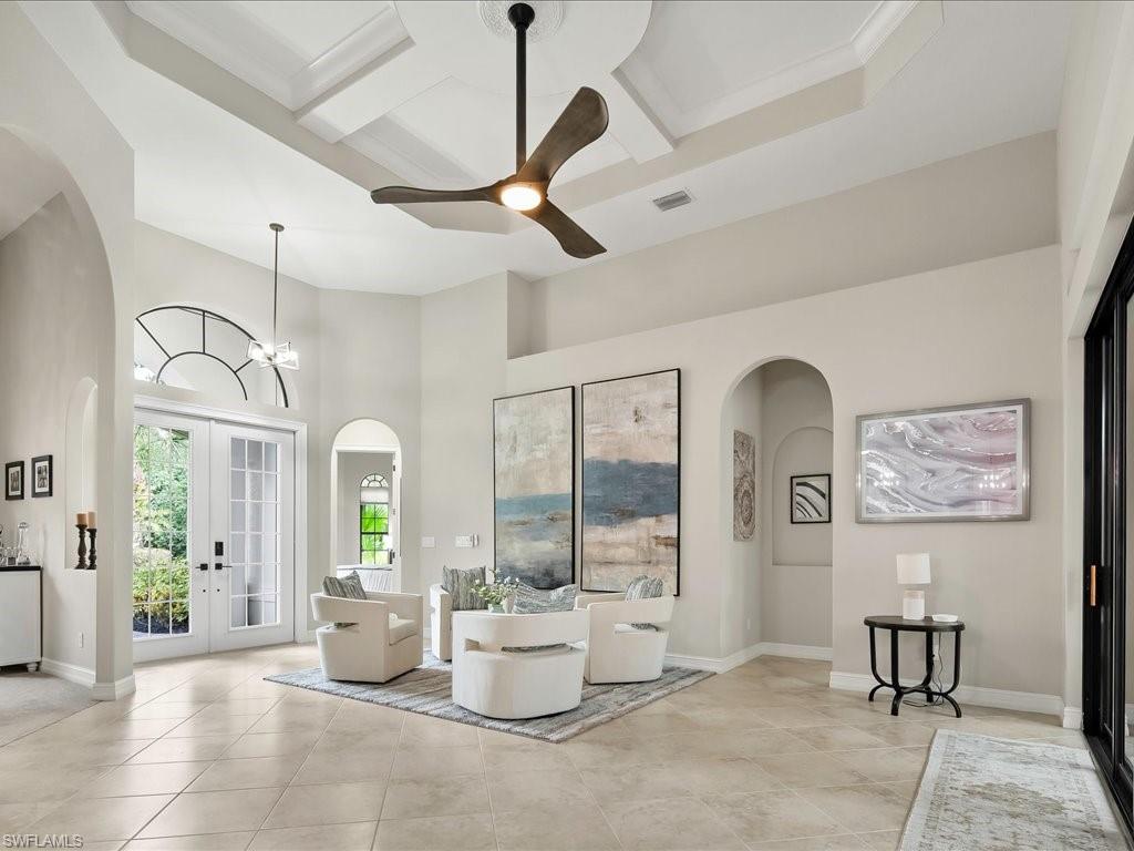 2360 19th Street Southwest Naples, FL 34117 - Photo 13 of 50 Living area featuring arched walkways, a ceiling fan, a high ceiling, tile patterned floors, and baseboards