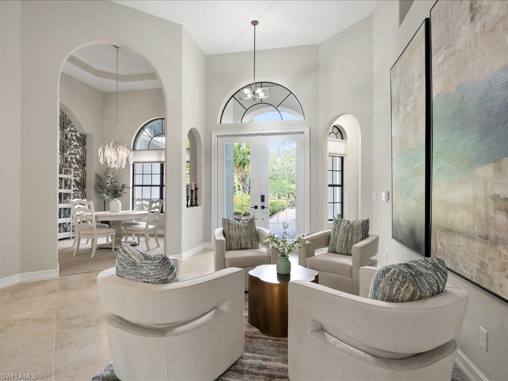 2360 19th Street Southwest Naples, FL 34117 - Photo 14 of 50 Living area with a chandelier, a high ceiling, baseboards, french doors, and arched walkways