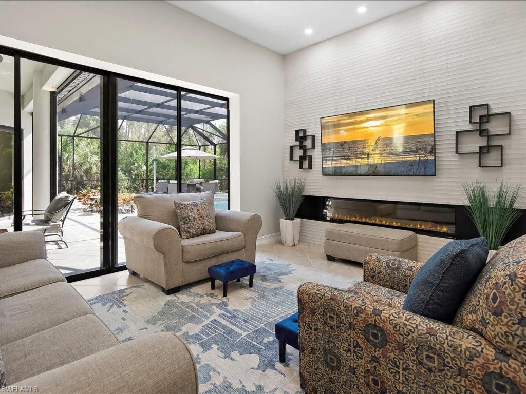 2360 19th Street Southwest Naples, FL 34117 - Photo 26 of 50 Tiled living room with recessed lighting, a glass covered fireplace, and baseboards
