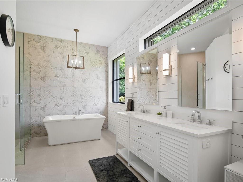 2360 19th Street Southwest Naples, FL 34117 - Photo 30 of 50 Full bath featuring double vanity, a soaking tub, a chandelier, and a shower stall