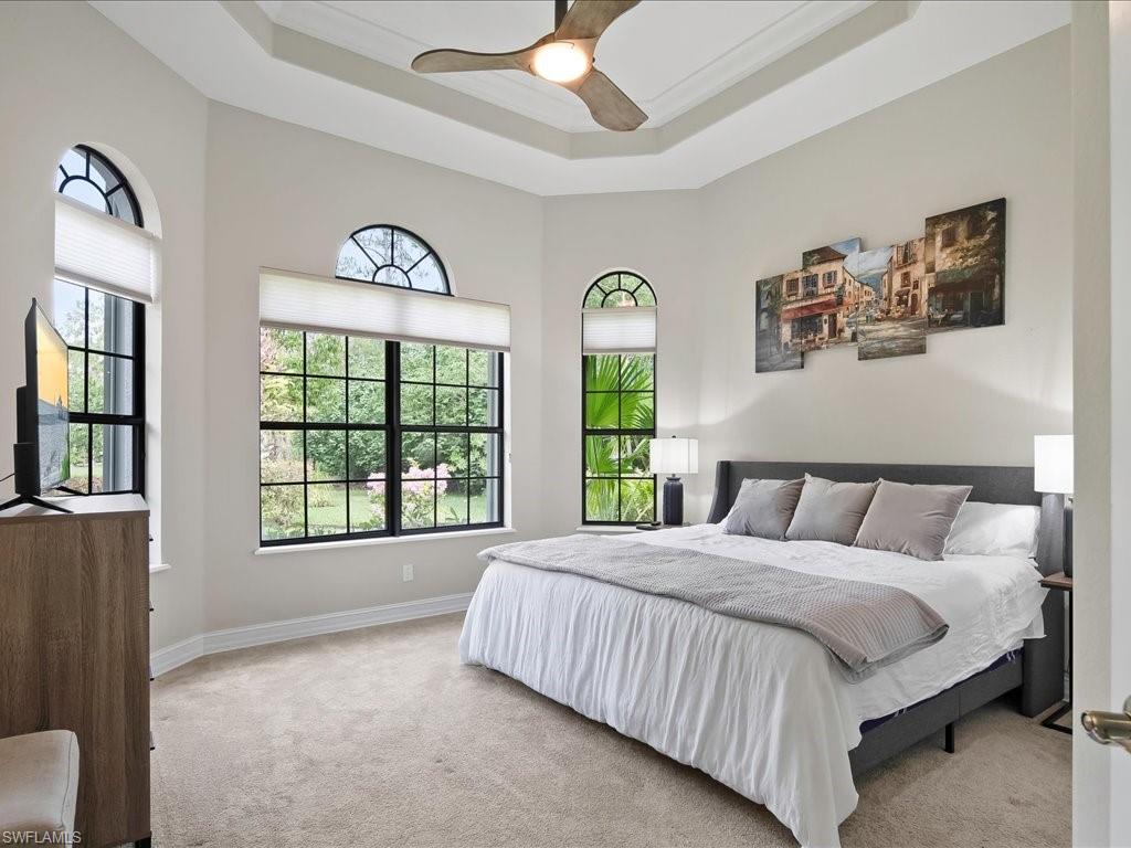 2360 19th Street Southwest Naples, FL 34117 - Photo 41 of 50 Carpeted bedroom featuring a tray ceiling, a ceiling fan, and baseboards