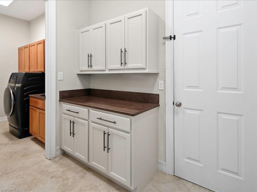 2360 19th Street Southwest Naples, FL 34117 - Photo 43 of 50 Laundry room featuring cabinet space, washer / clothes dryer, baseboards, and light tile patterned floors