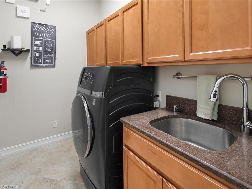 2360 19th Street Southwest Naples, FL 34117 - Photo 44 of 50 Laundry room featuring washer / dryer, cabinet space, baseboards, and light tile patterned floors