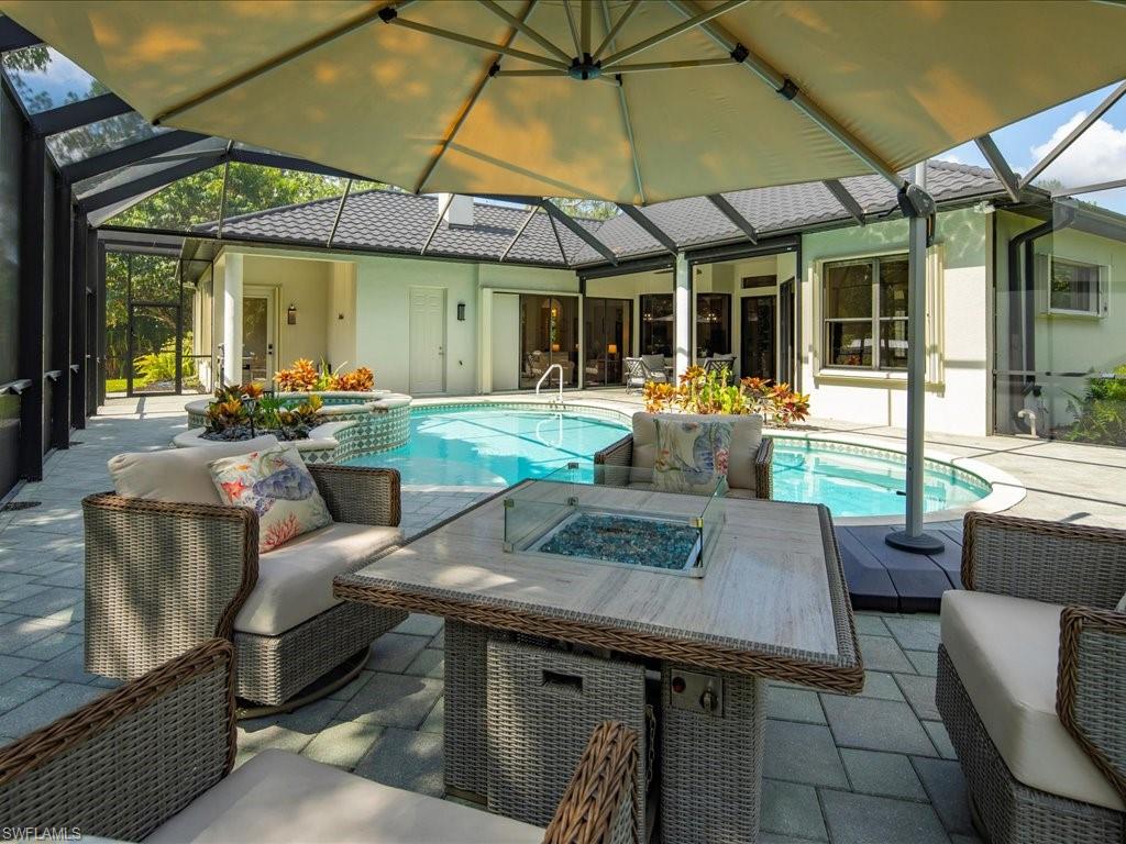 2360 19th Street Southwest Naples, FL 34117 - Photo 46 of 50 Outdoor pool featuring an in-ground hot tub, an outdoor living space with a fire pit, a lanai, and a patio area