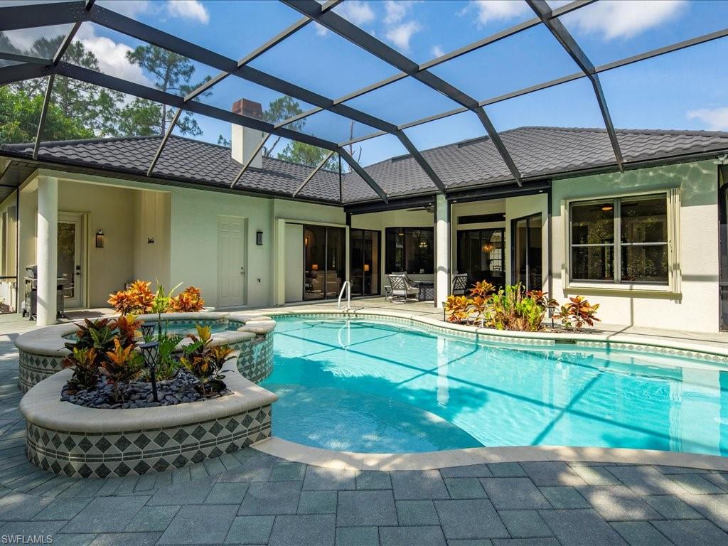 2360 19th Street Southwest Naples, FL 34117 - Photo 10 of 50 View of swimming pool featuring a patio area, a pool with connected hot tub, and glass enclosure