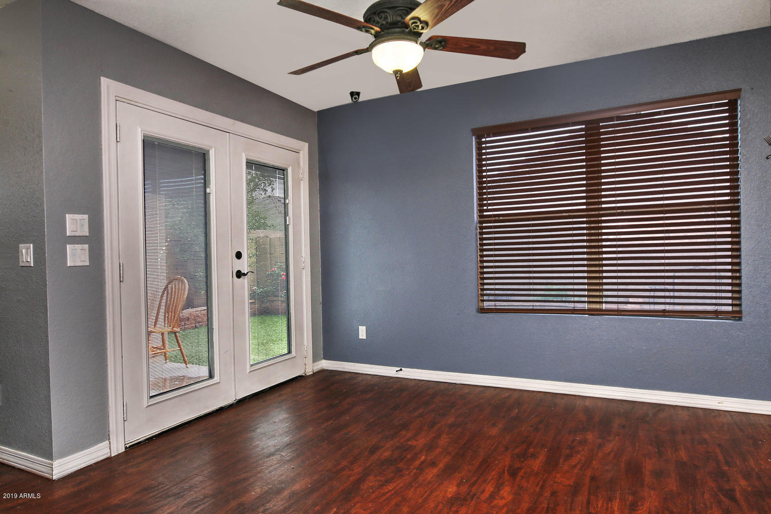 3288 South Chaparral Road Apache Junction, AZ 85119 - Photo 12 of 29 an empty room with wooden floor chandelier fan and windows