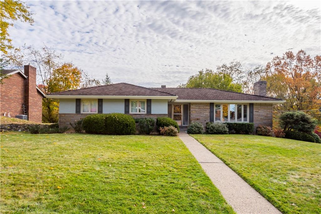 a front view of a house with yard and green space