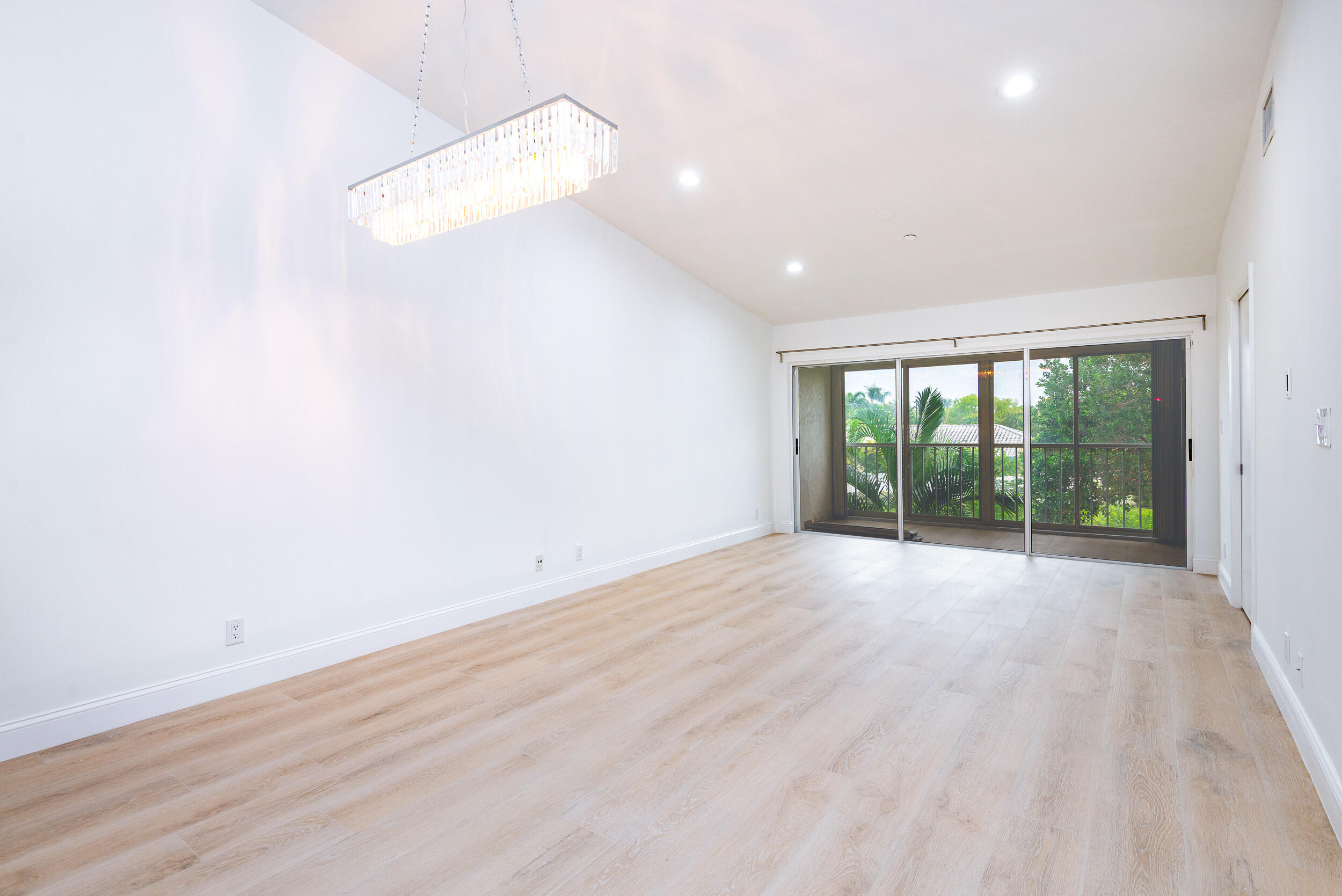 380 Northwest 67th Street, Unit J204 Boca Raton, FL 33487 - Photo 14 of 43 a view of an empty room with wooden floor and a window