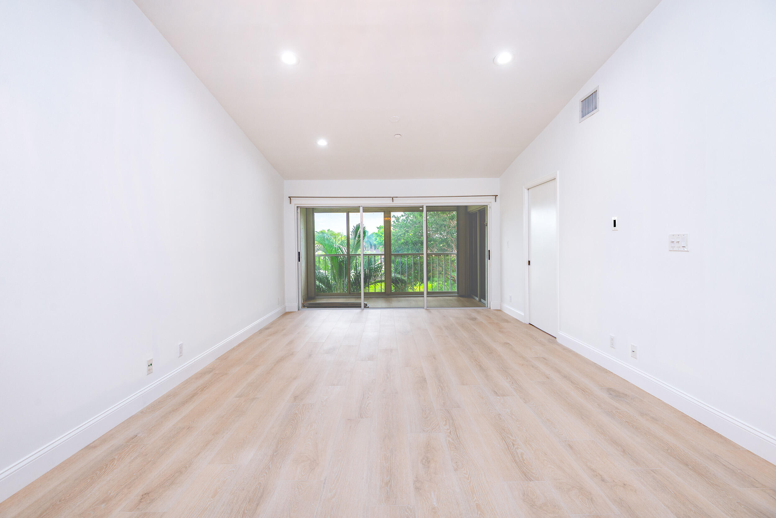 380 Northwest 67th Street, Unit J204 Boca Raton, FL 33487 - Photo 15 of 43 an empty room with wooden floor and windows